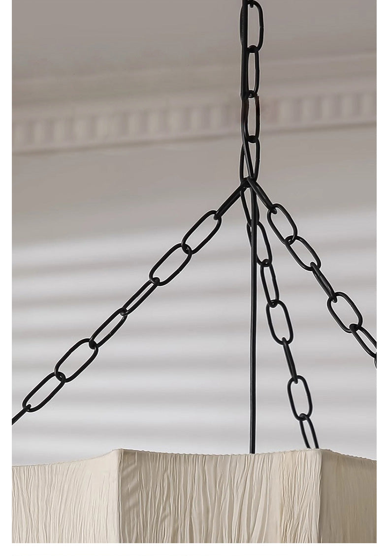 brass pendant chain hanging from a ceiling fixture against a neutral background