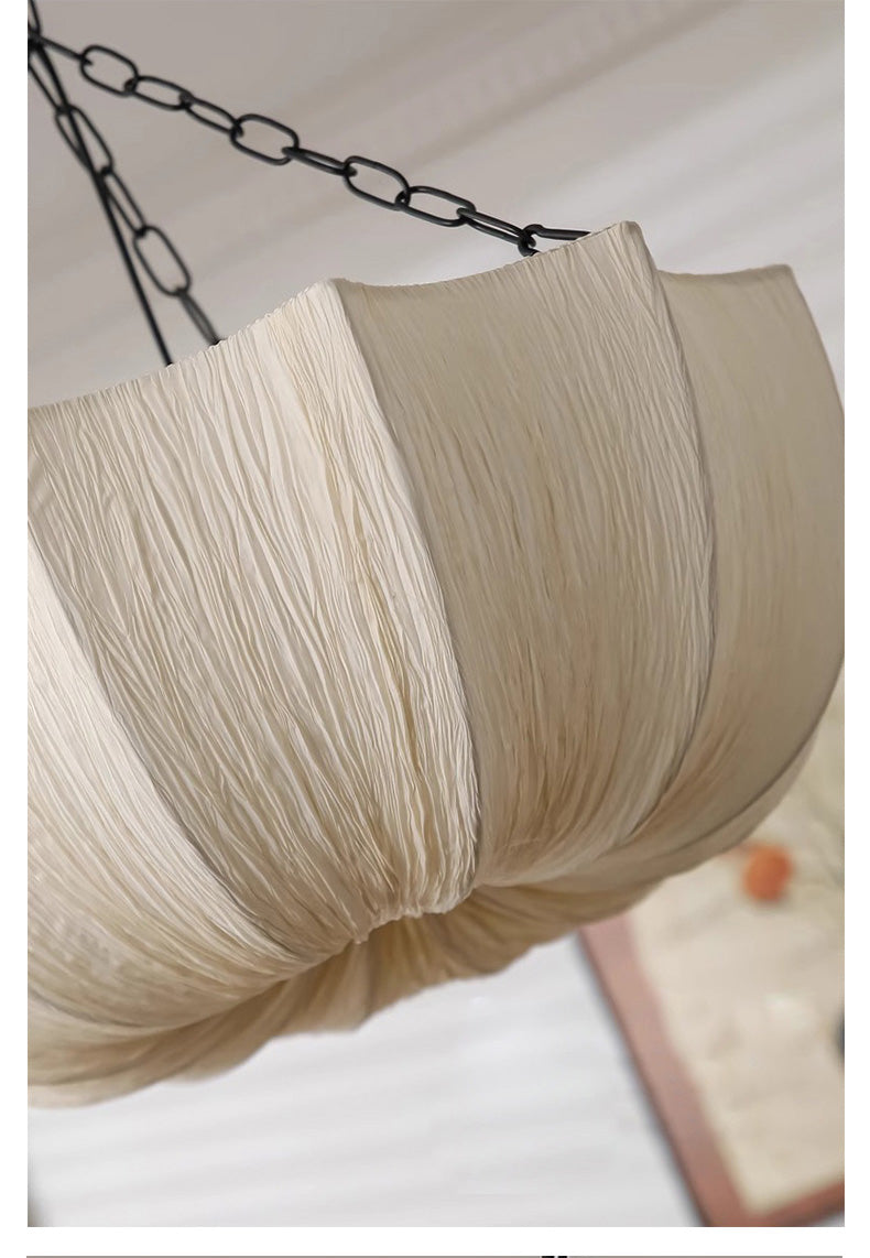 Close-up of a beige cotton lampshade with a chain on a light background