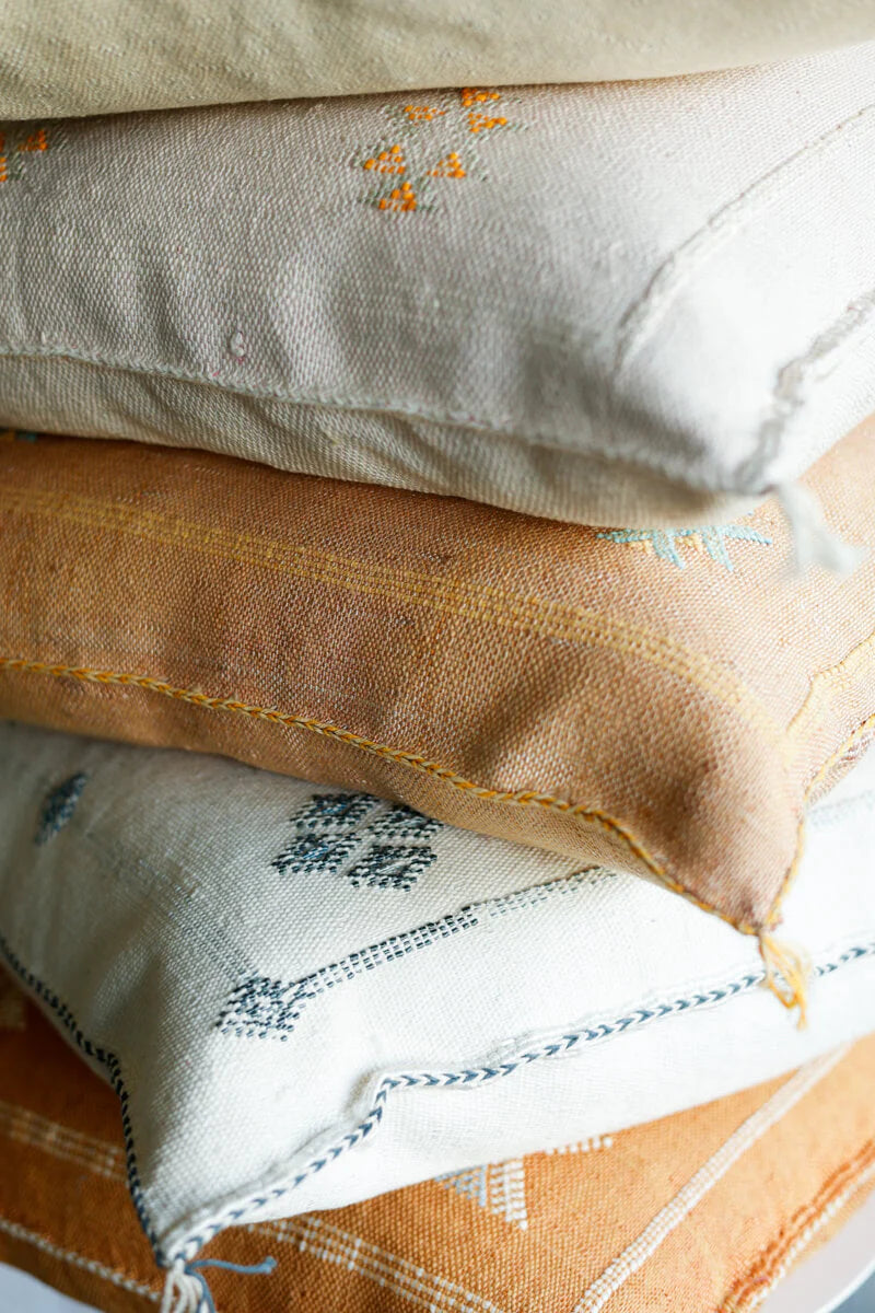Stack of embroidered Cushion samples in various colors