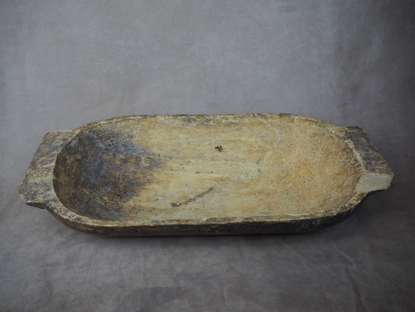 Ancient stone basin on a gray background
