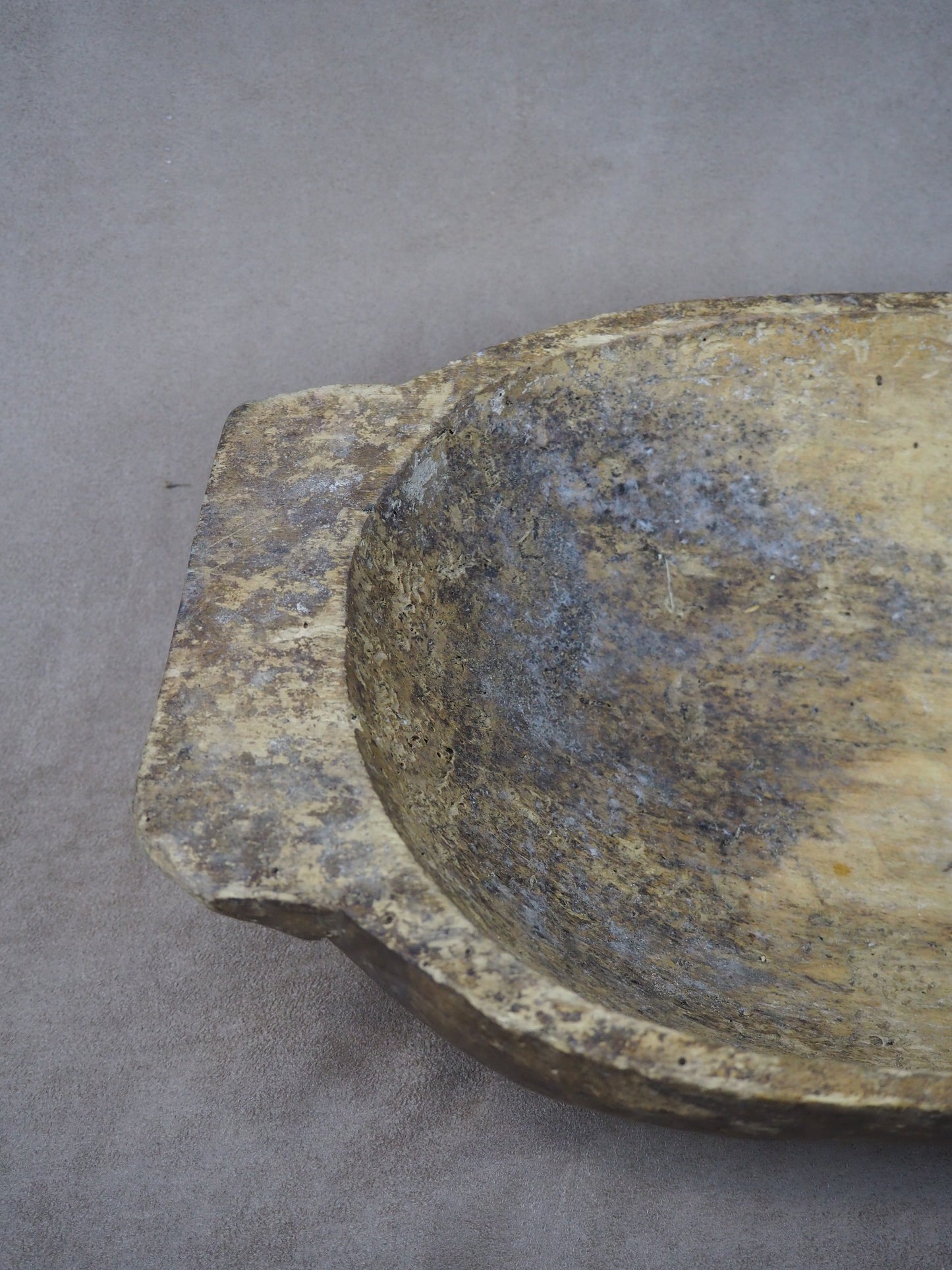 Close-up of a wooden bowl with a textured surface on a gray background