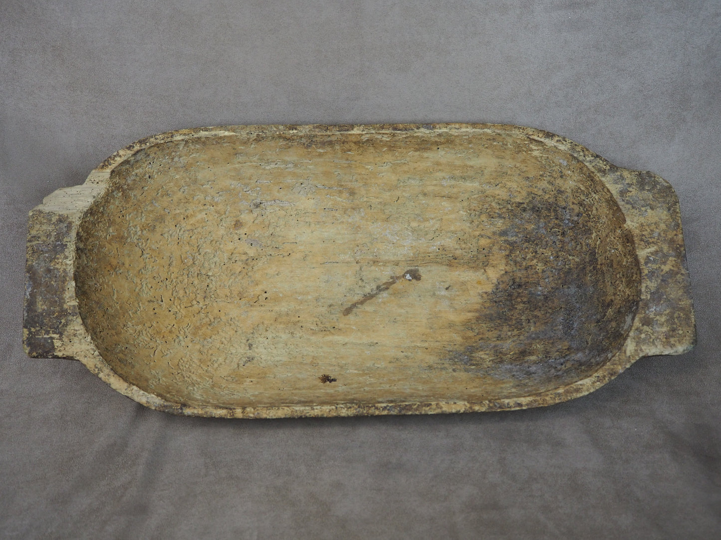 Rectangular wooden tray with a worn surface on a gray background