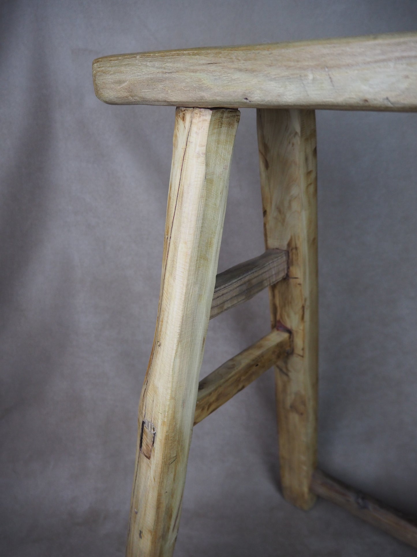 Close-up of a wooden stool with a plain background