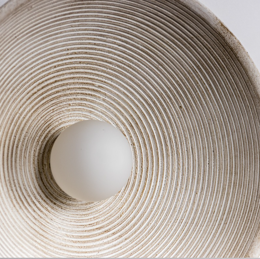 Close-up of a white sphere inside a textured circular container