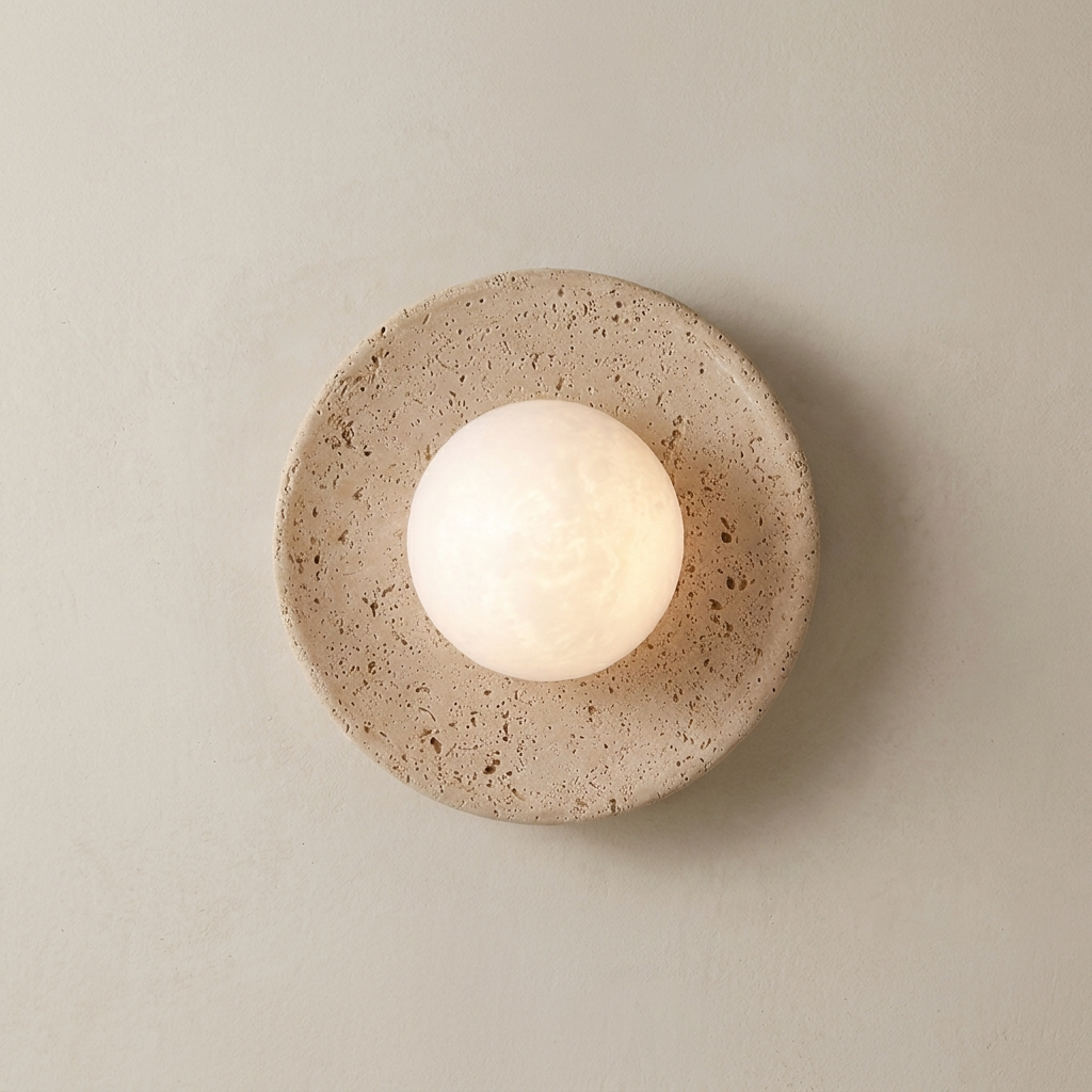 Round travertine wall light fixture with a textured beige base on a plain wall.