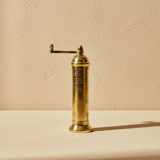 Gold pepper grinder on a white background
