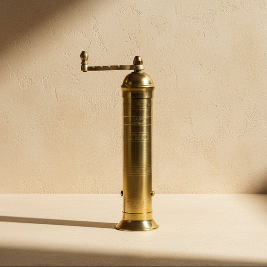 Brass pepper grinder on a white background