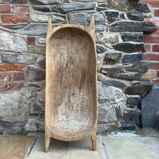 Wooden trough against a stone wall