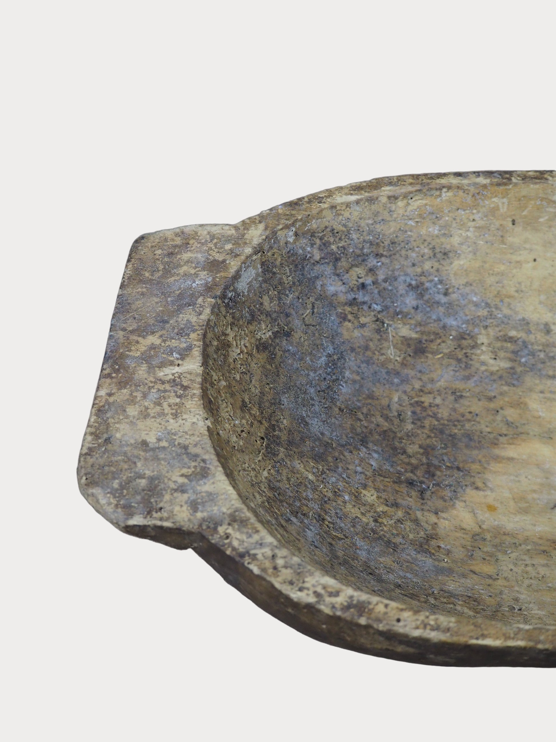 Close-up of a wooden bowl with a textured surface on a gray background