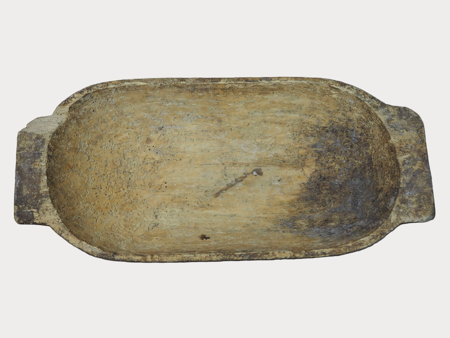 Rectangular wooden dough bowl with a worn surface on a gray background
