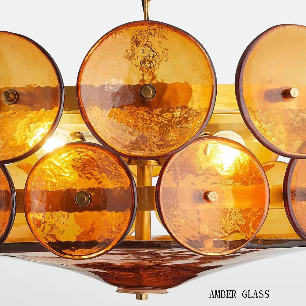 Amber glass light fixture with a gold base on a white background