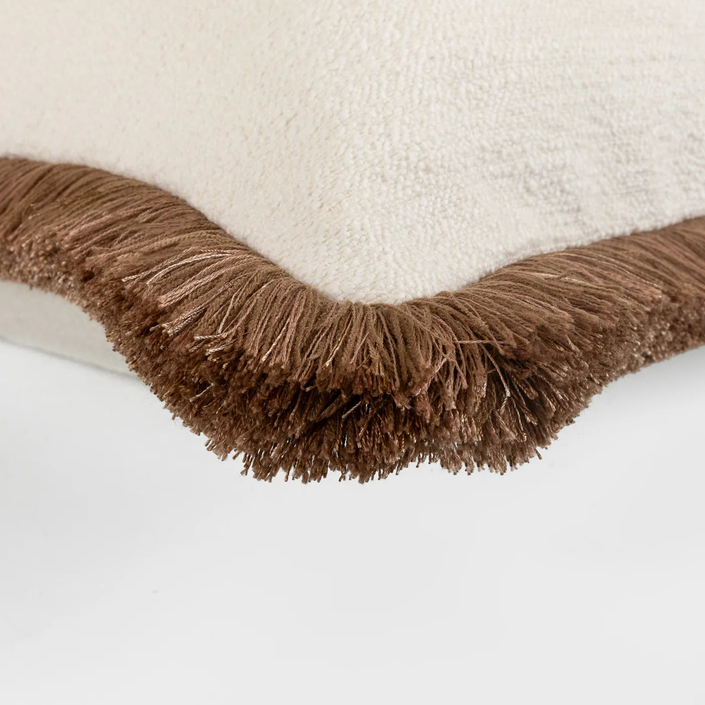 Three decorative pillows with brown fringes on a white background