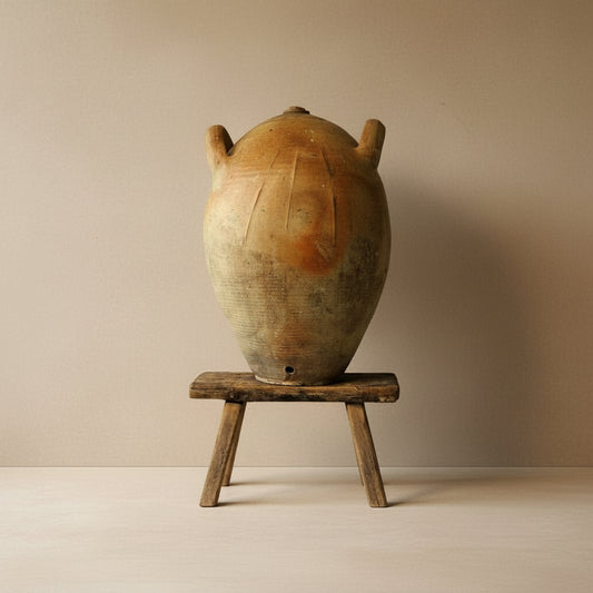 Vintage ceramic pot on a wooden stand against a plain background