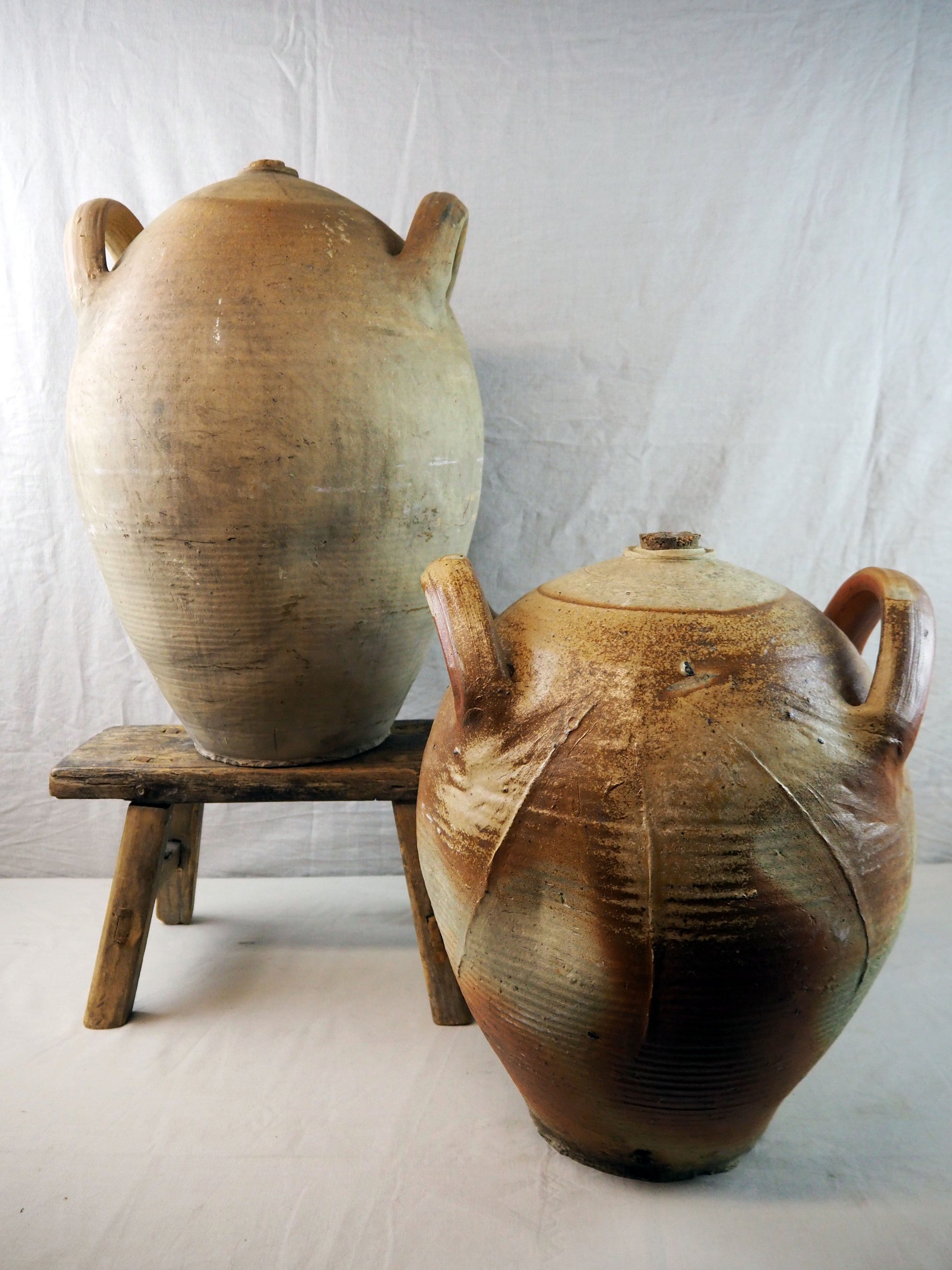 Two ceramic pots with handles on a white background