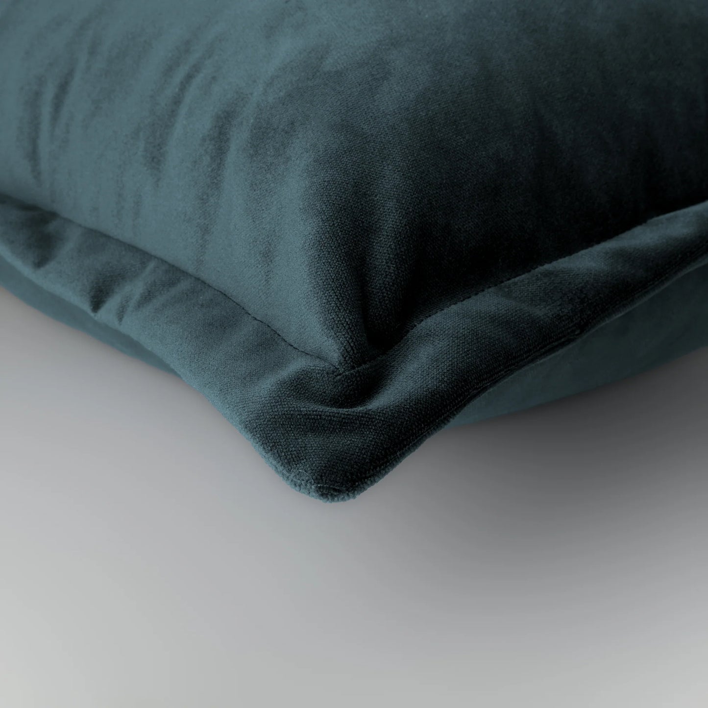 Grey velvet pillow on a light gray background