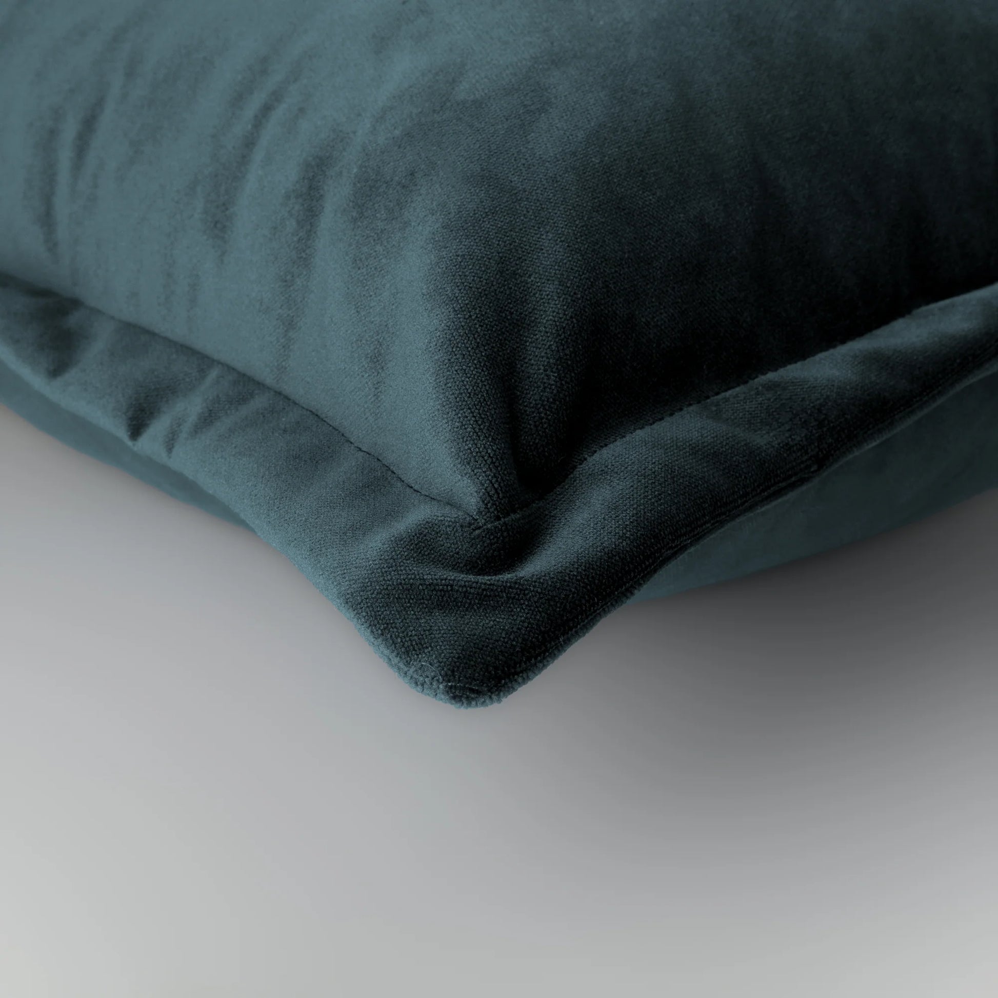 Grey velvet pillow on a light gray background