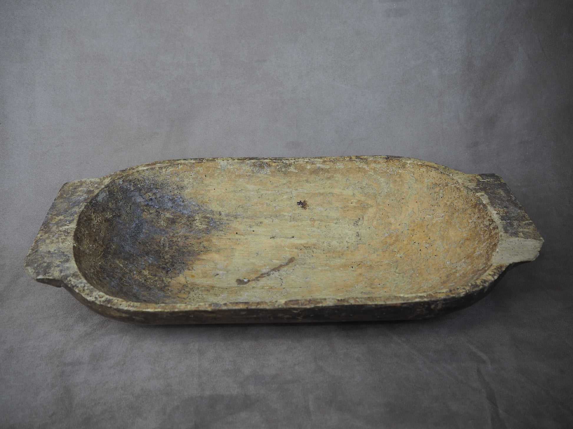 Ancient stone basin on a gray background