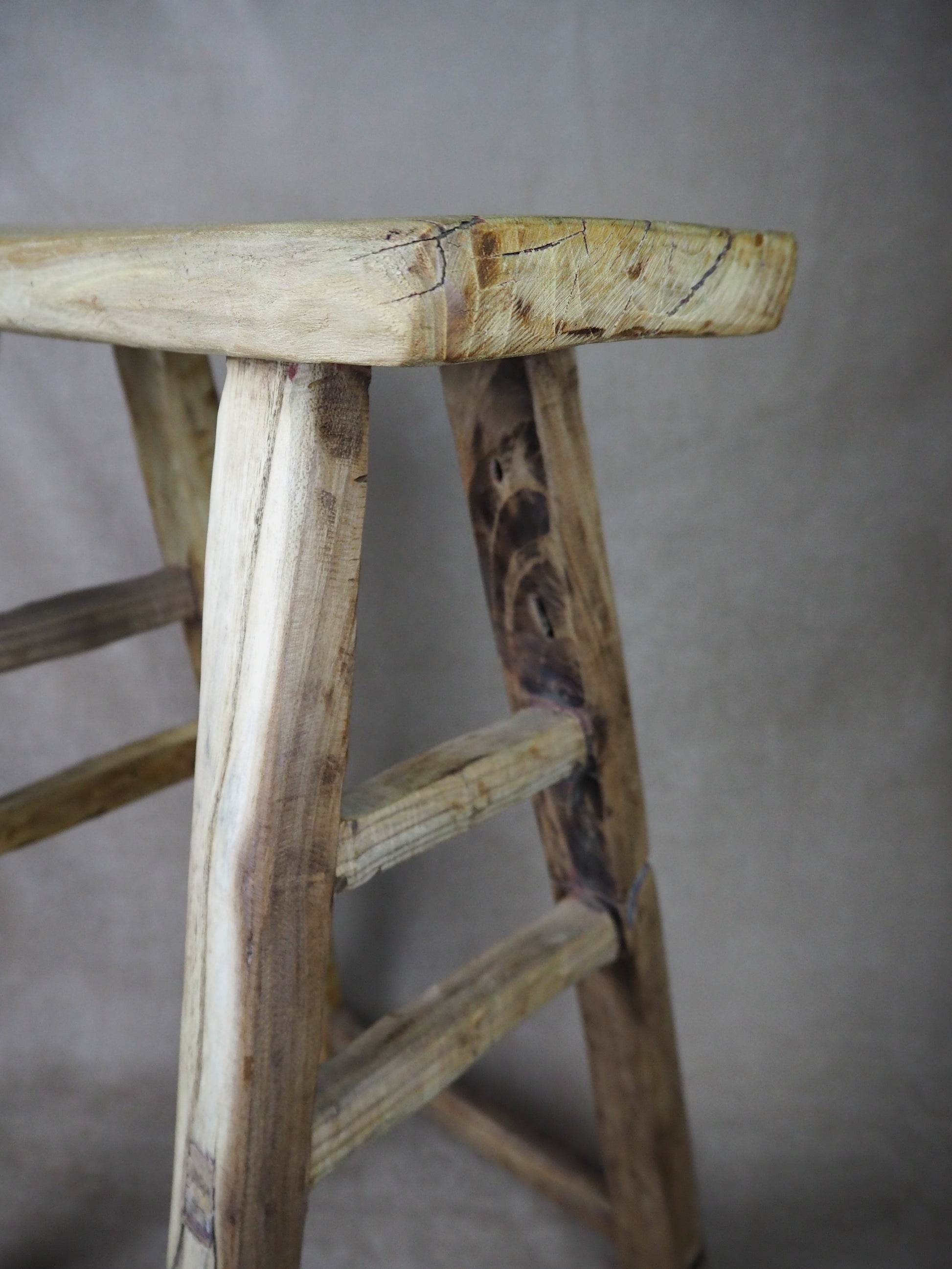 Close-up of a wooden ladder with a plain background