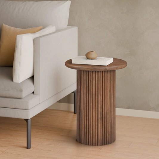 Wooden side table next to a gray sofa with a beige pillow