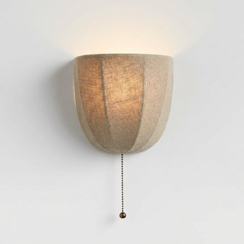 Wall-mounted lamp with a textured linen
 shade on a plain background