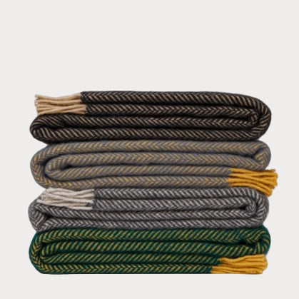 Stack of folded blankets in various colors on a white background
