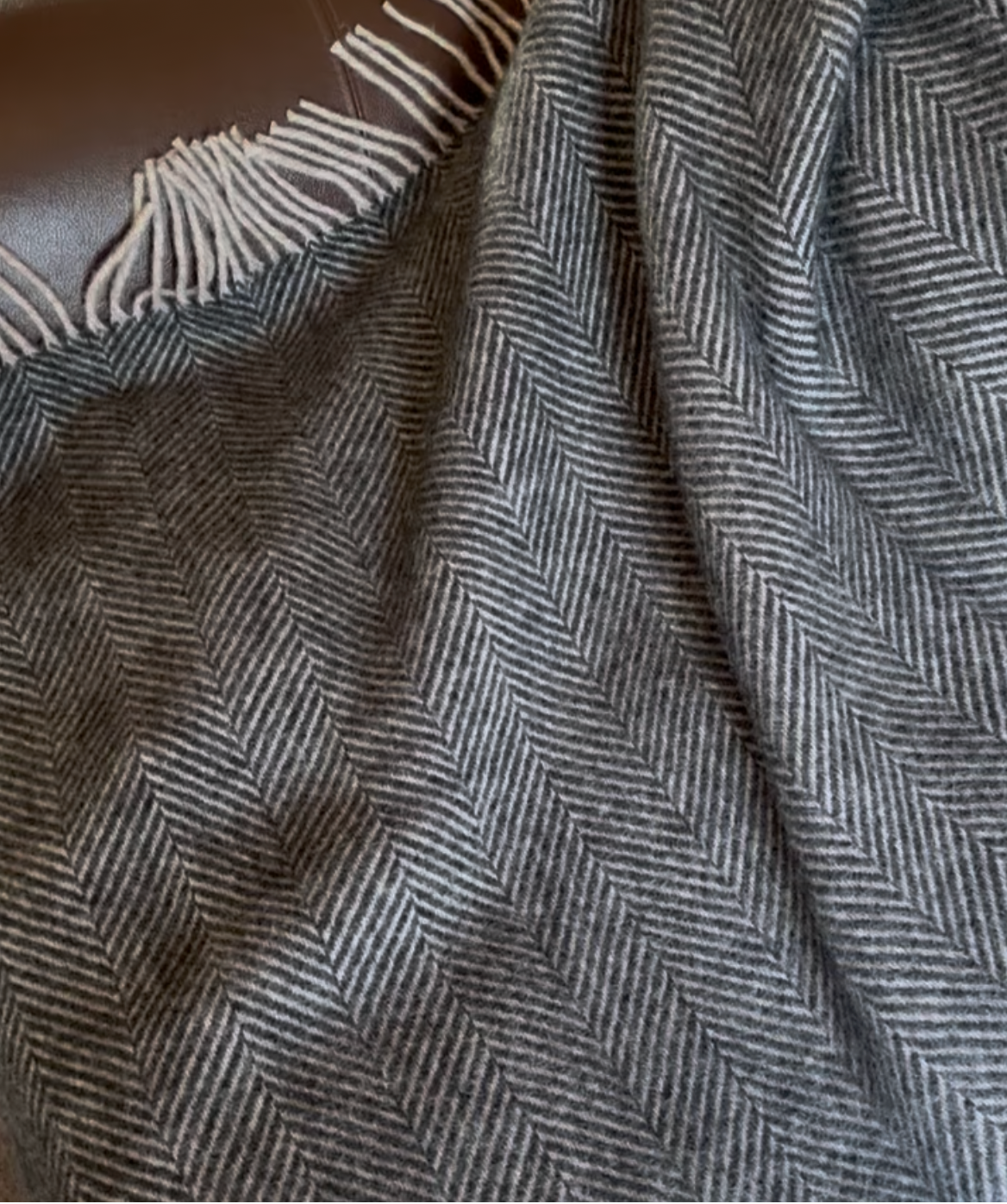 Textured blanket draped over a sofa with a neutral background