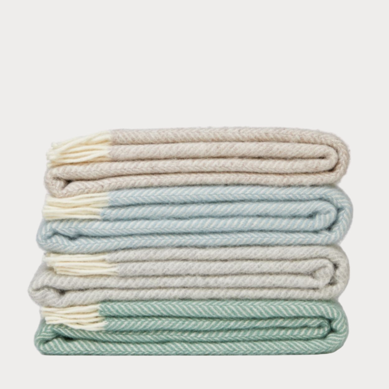 Stack of folded blankets in pastel colors on a white background