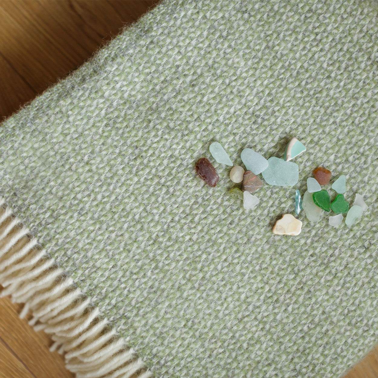 Small collection of multicolored stones on a textured green fabric surface.