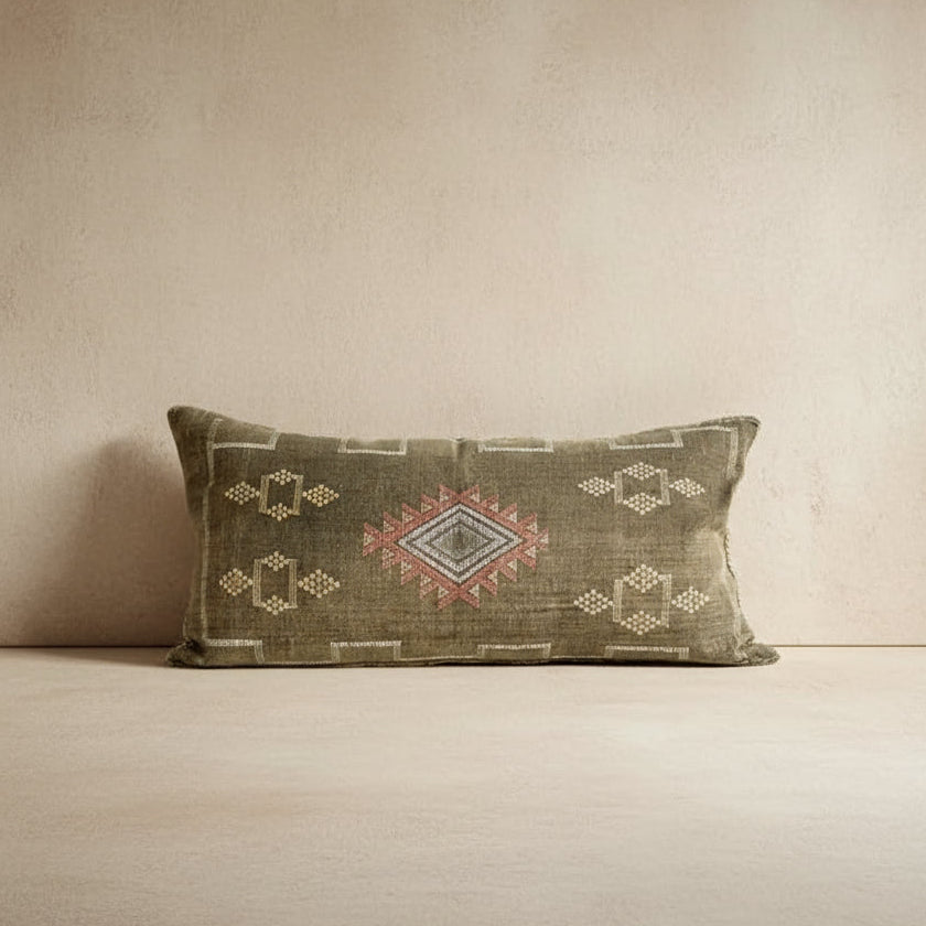 Decorative pillow with geometric patterns on a textured wall background