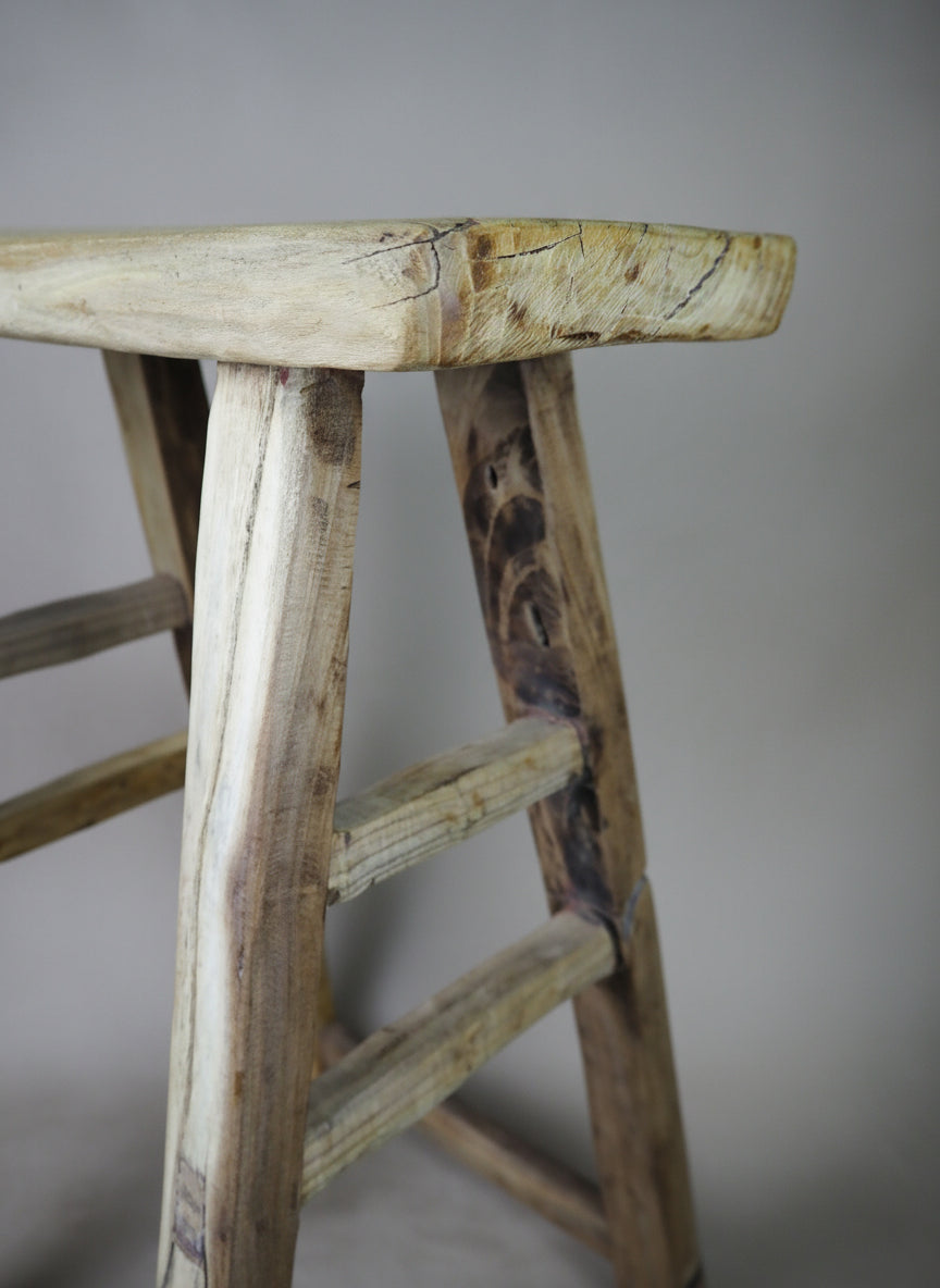 Close-up of a wooden ladder with a plain background
