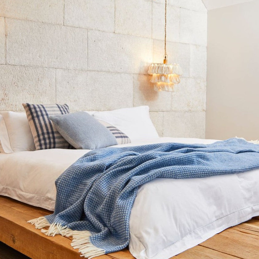 waffle textured throw blanket in bluebell styled on bed made in britain