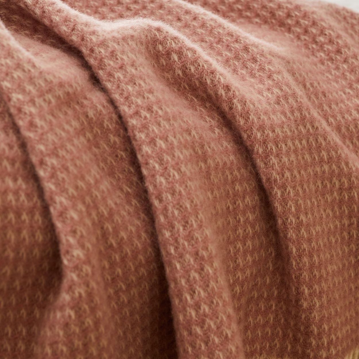Close-up of Waffle throw in dusky pink  textured fabric made in britain