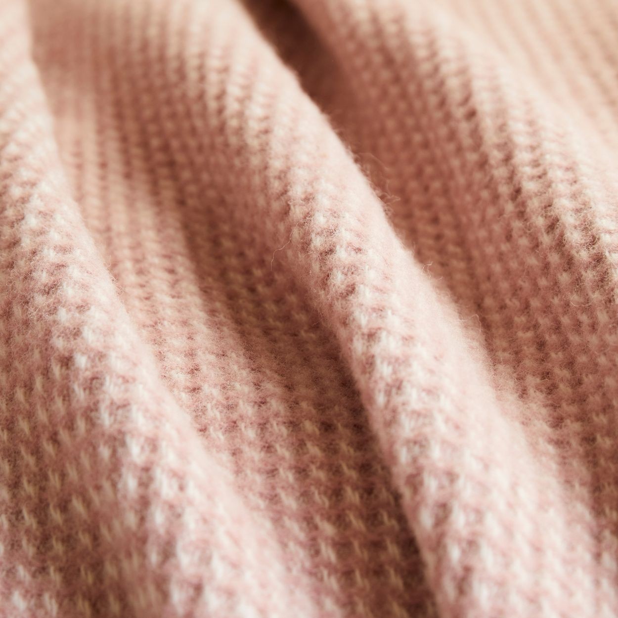 Close-up of Waffle throw in dusky pink  textured fabric pure new wool